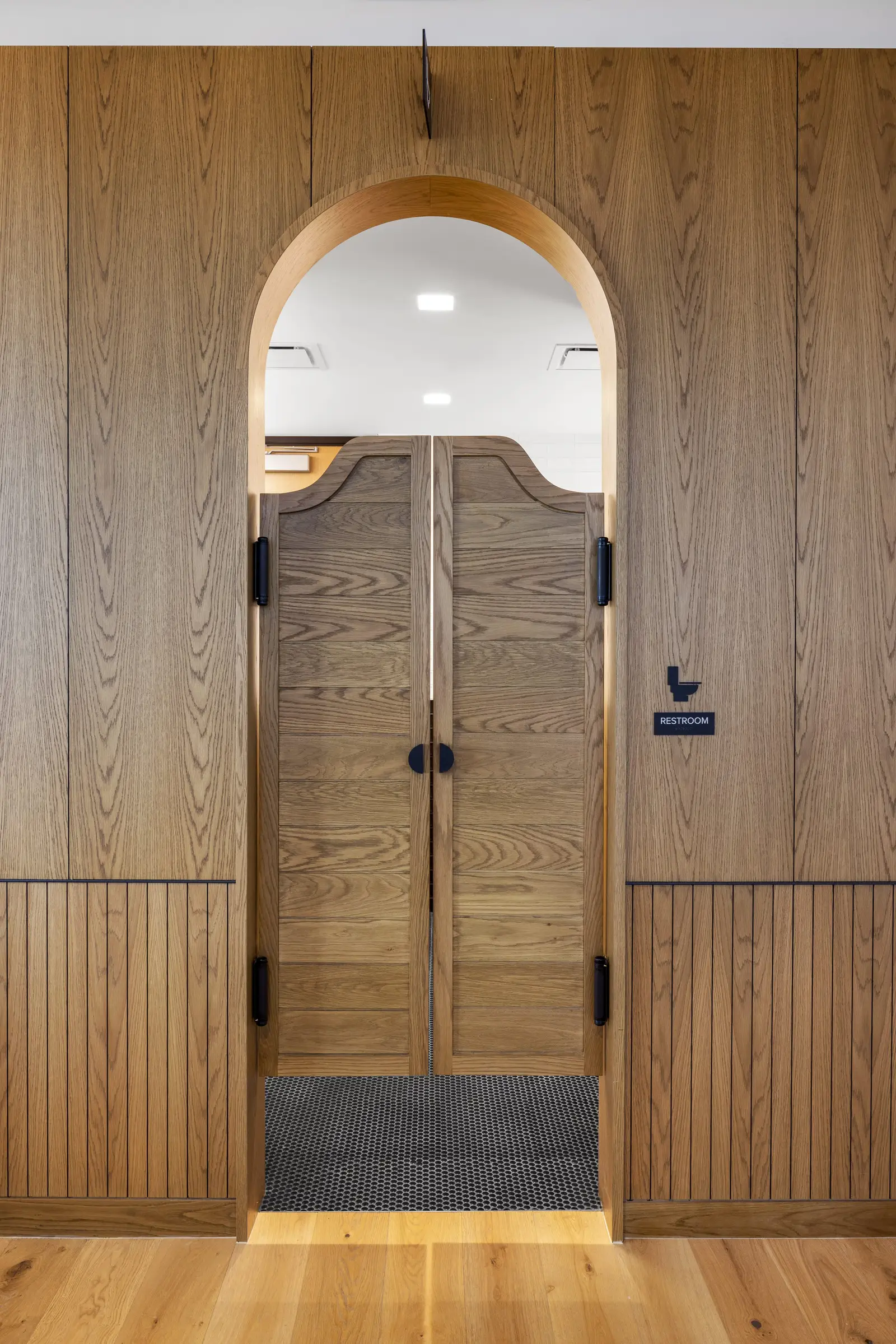 Unity tall arched swinging wood doors in a paneled wall