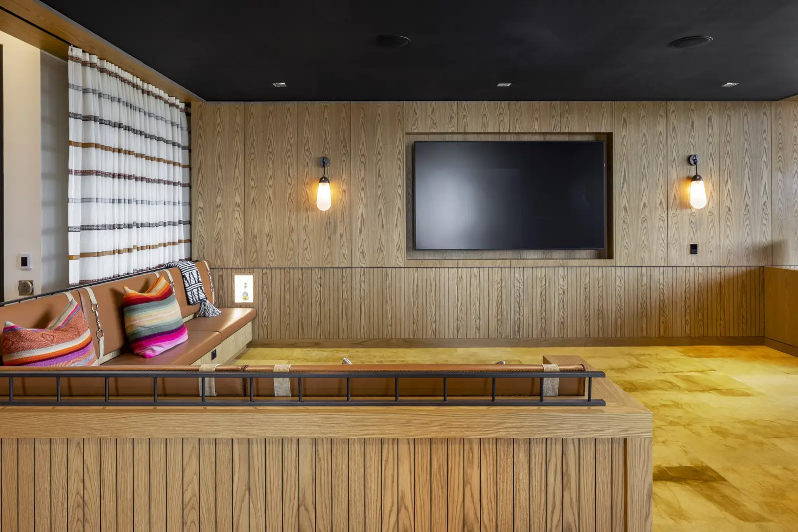 Unity lounge with a wood-paneled wall, TV and sconces