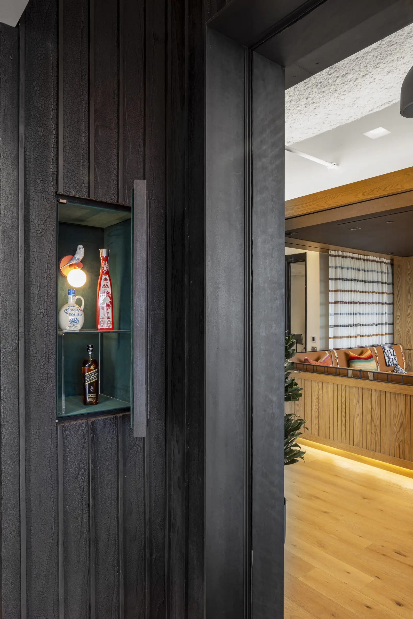 Unity dark wood column with a small lit niche