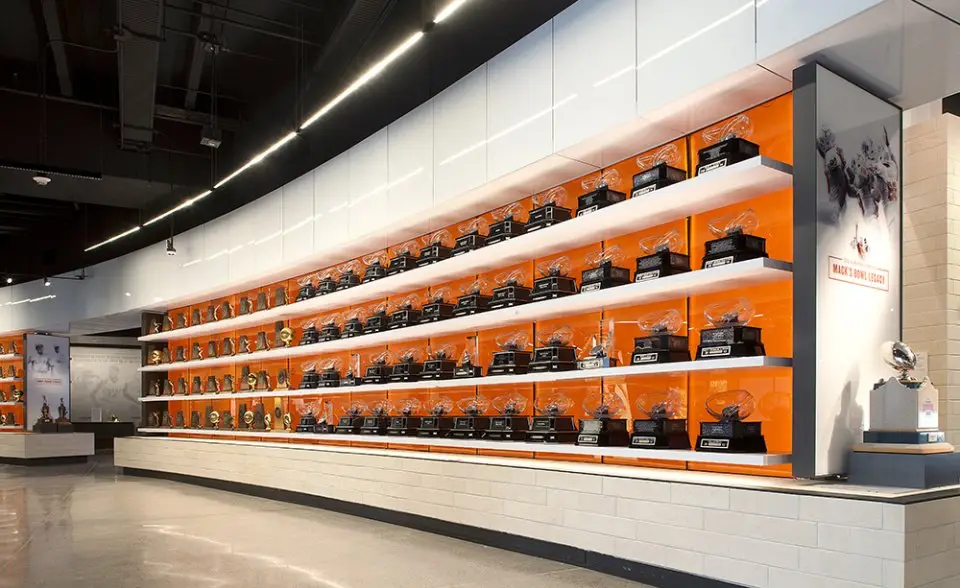 University of Texas Hall of Fame curved wall of display shelves with orange backing and helmets