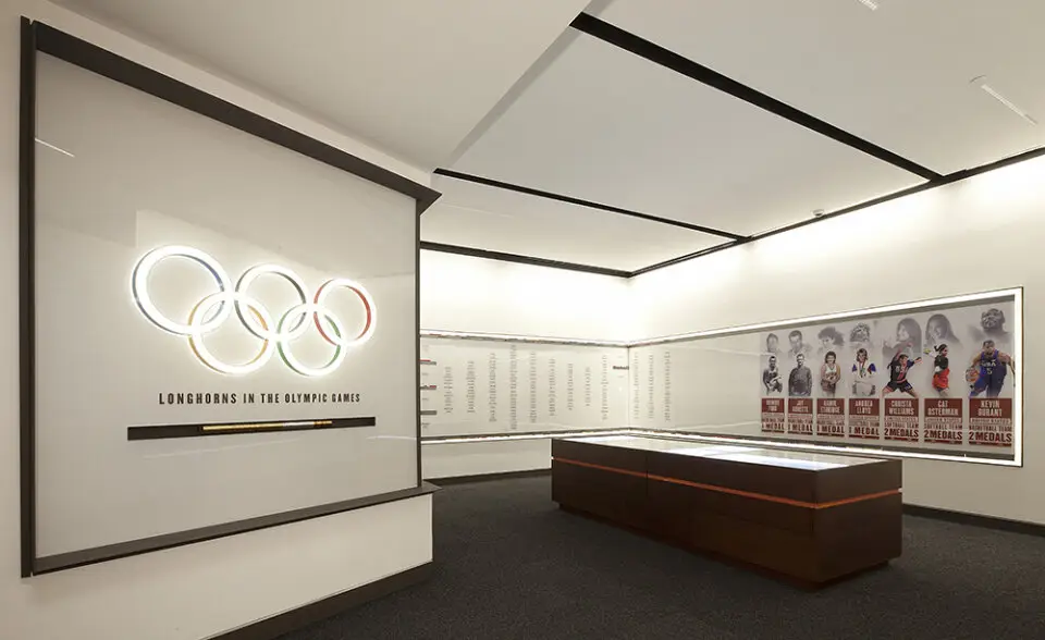 University of Texas Hall of Fame exhibit wall with Olympic rings and a wood display case