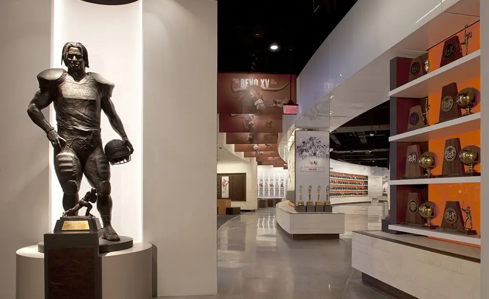 University of Texas Hall of Fame football player statue in a lit niche beside display shelves