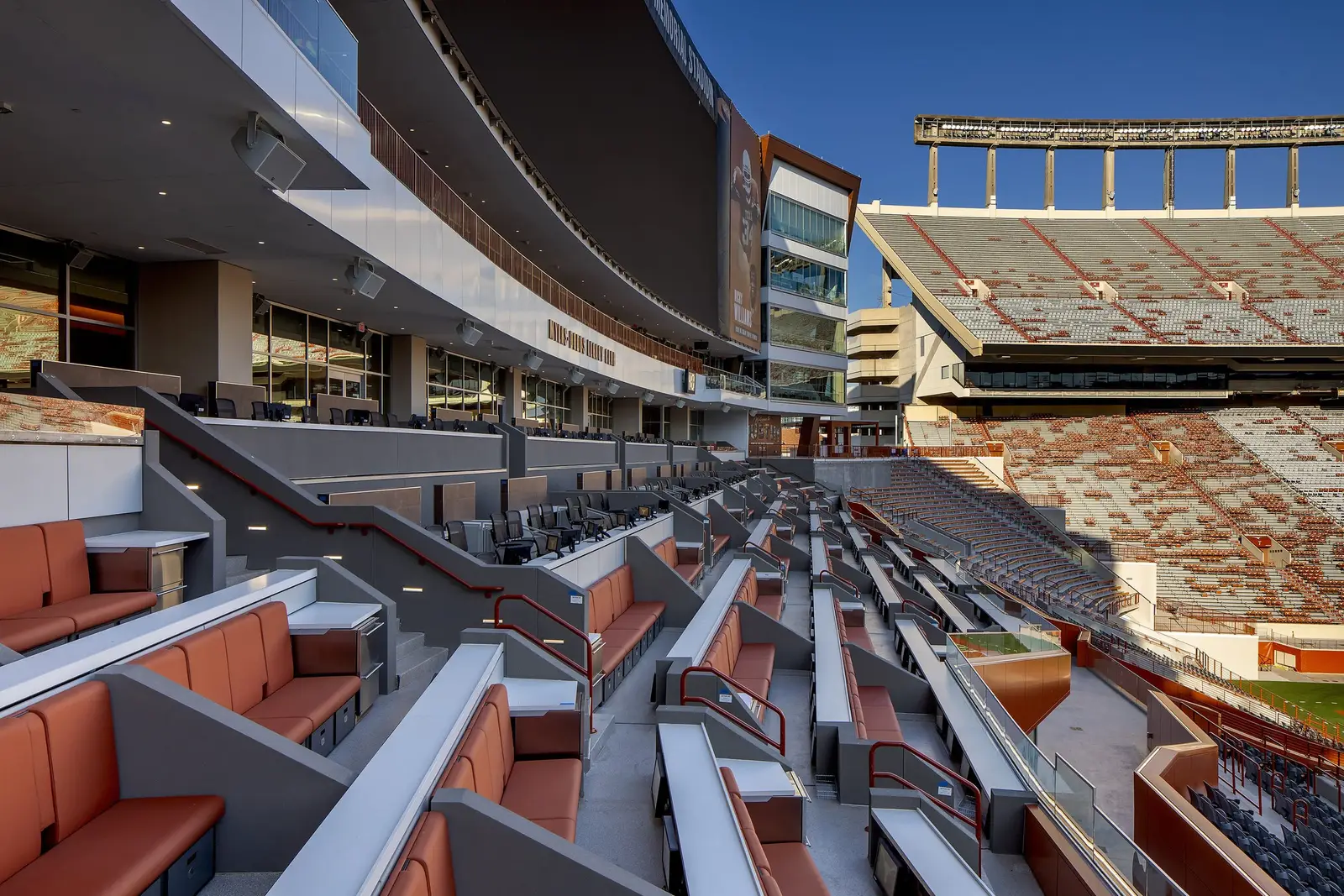 University of Texas South End Zone stadium seating with orange cushioned seats beside the field