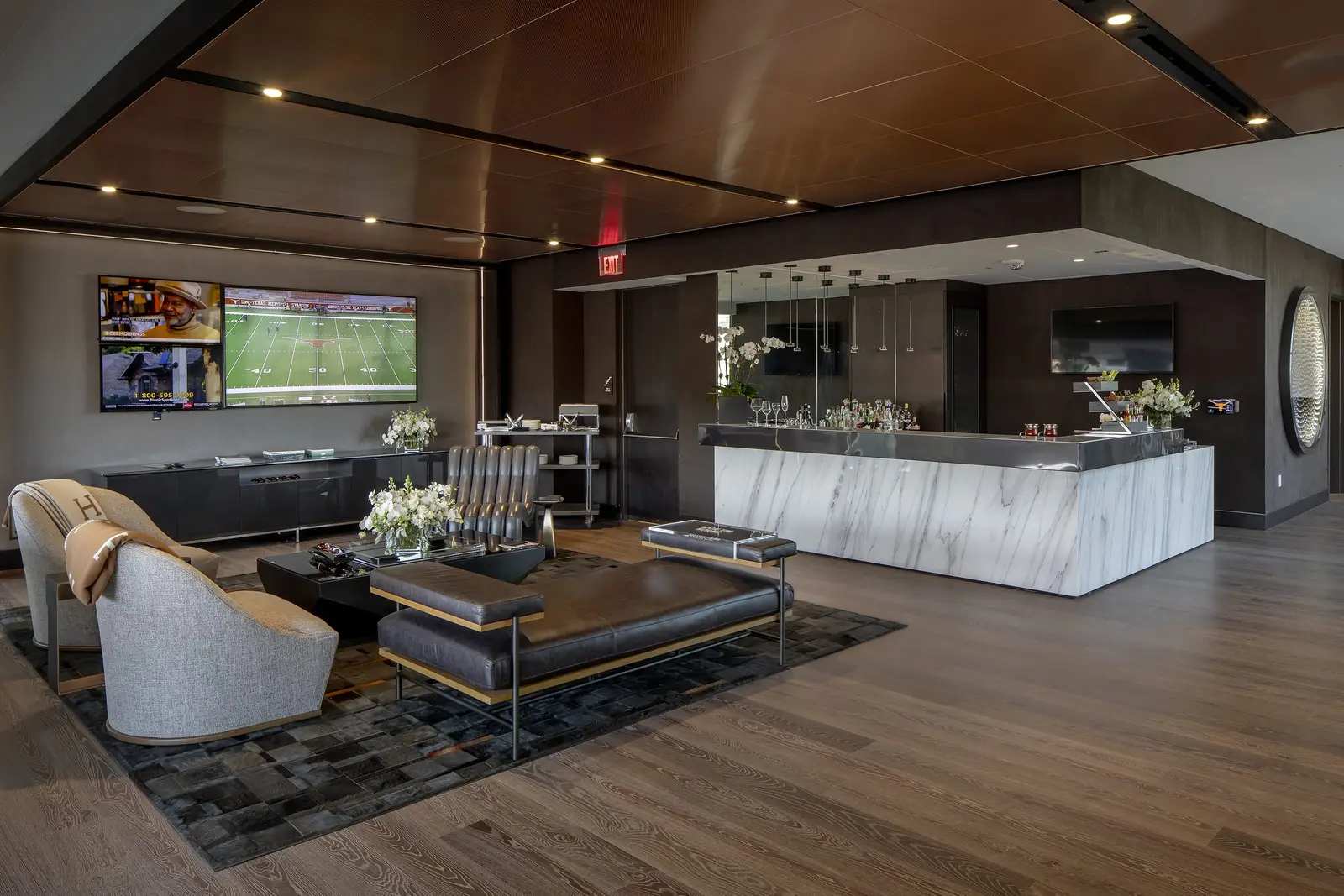 University of Texas South End Zone club lounge with seating, a wood ceiling and a white stone bar