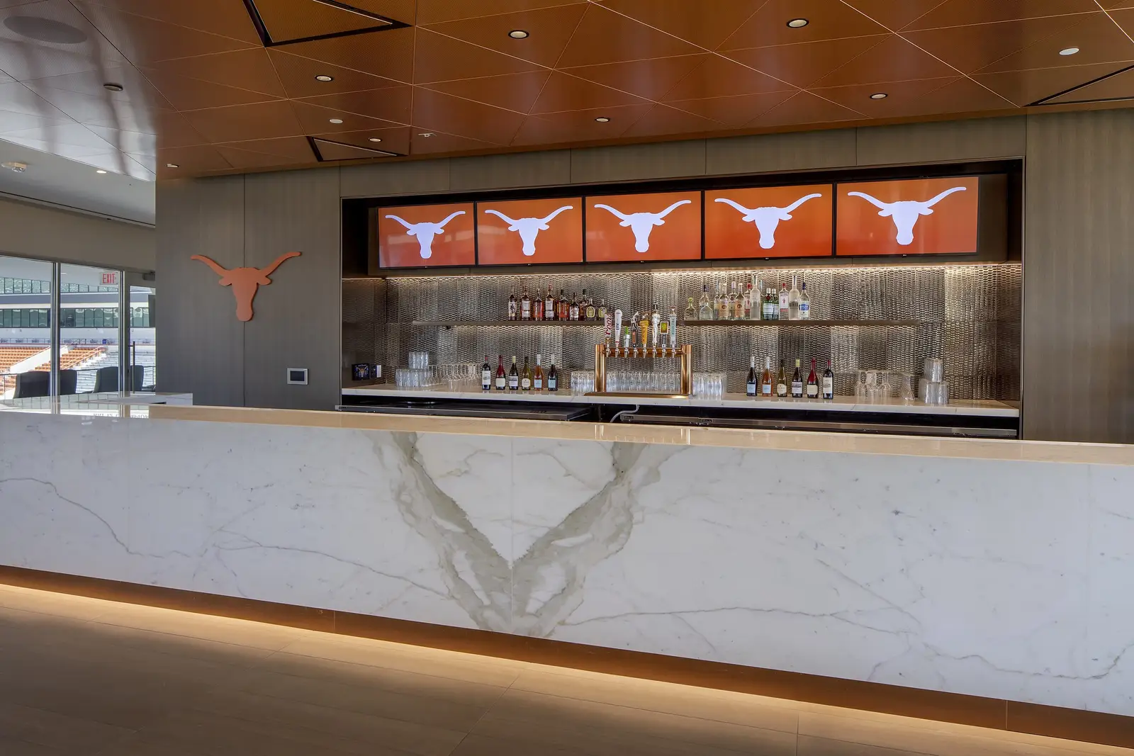 University of Texas South End Zone white stone bar with a back bar of Longhorn logo screens