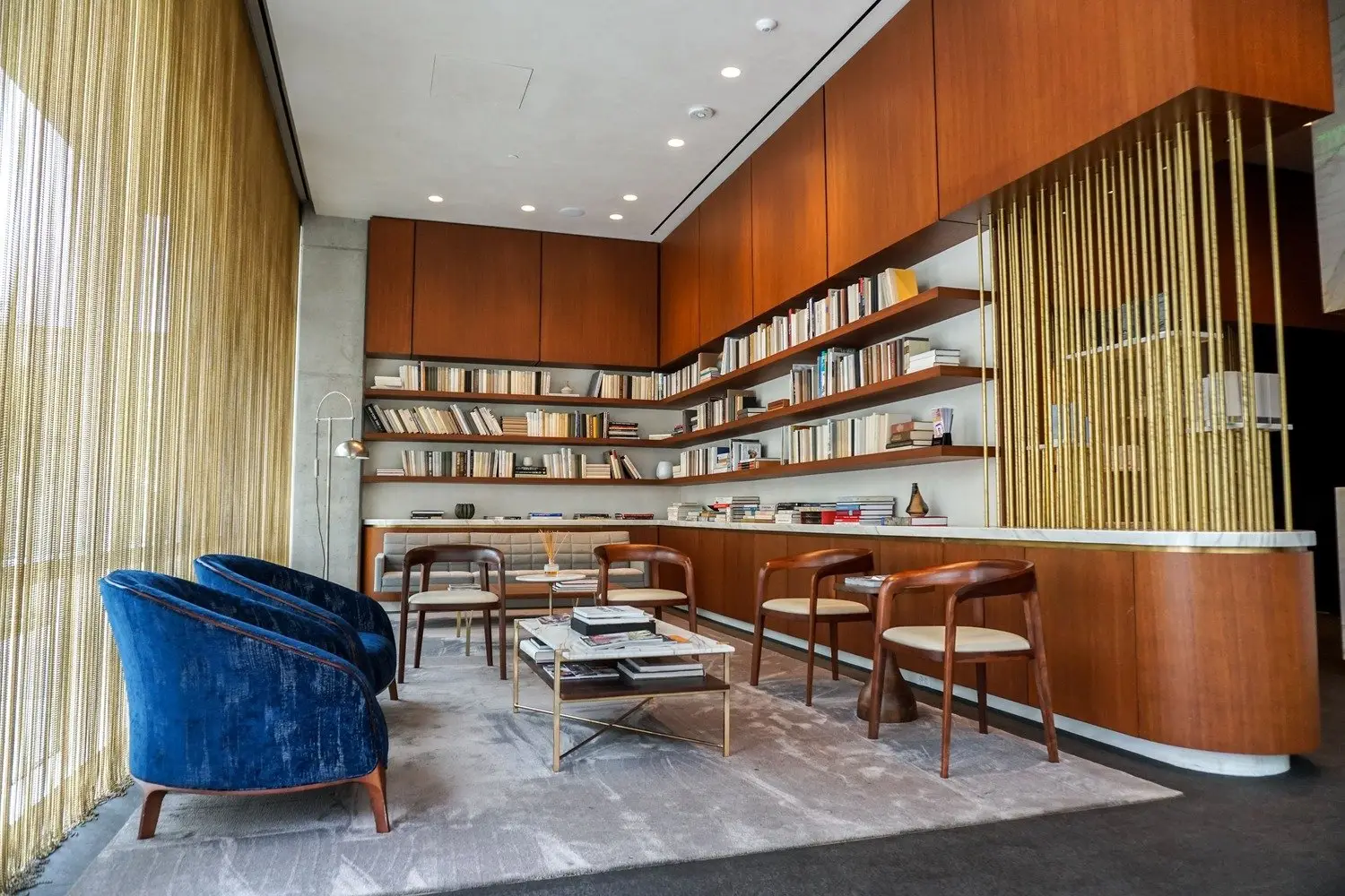 Westlake Dermatology waiting area with blue chairs, wood cabinetry and built-in bookshelves