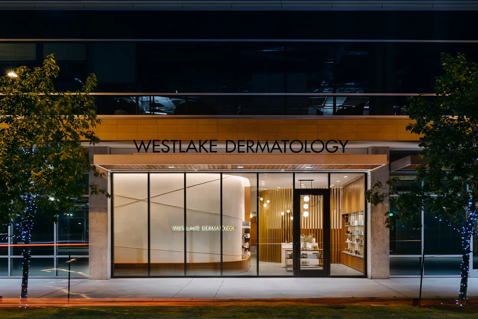 Westlake Dermatology clinic storefront at night with the Westlake Dermatology sign