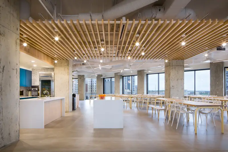 Workrise (formerly Rigup) open dining area with a wood slat ceiling and concrete columns