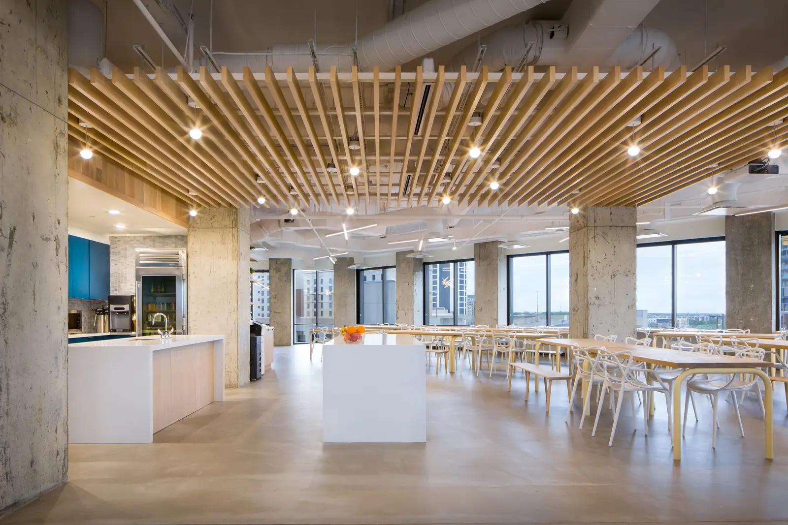 Workrise (formerly Rigup) open dining area with a wood slat ceiling and concrete columns