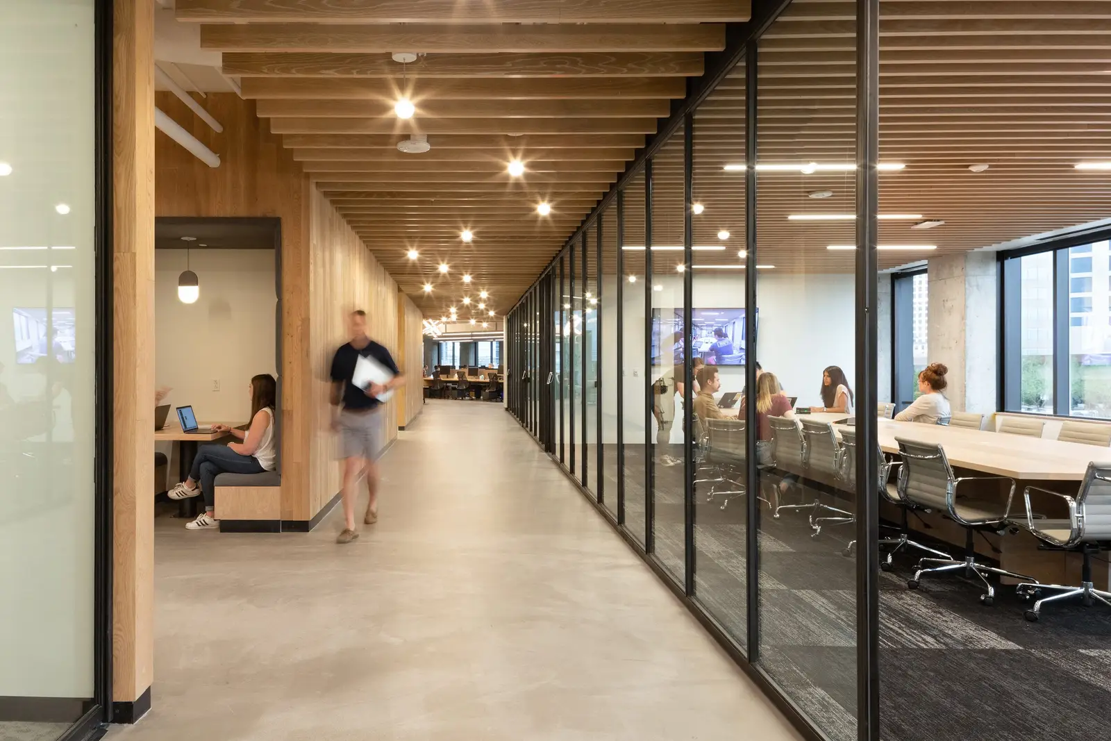 Workrise (formerly Rigup) corridor with a wood slat ceiling and a glass-walled conference room