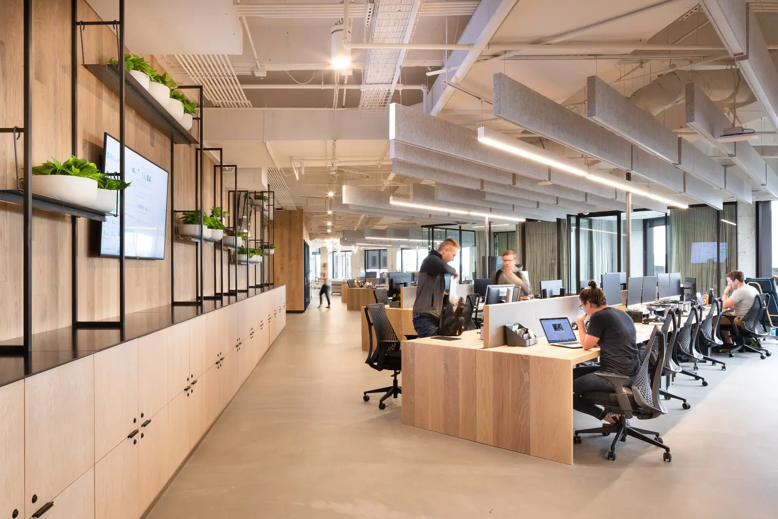 Workrise (formerly Rigup) open office with wood-front cabinets and a metal shelf frame